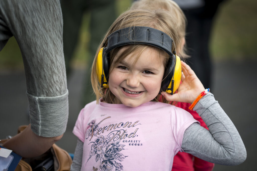 Vergroot afbeelding: Foto van een meisje met een koptelefoon op tegen geluidsoverlast.